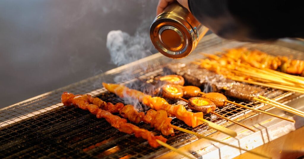 炭火で焼かれるジンギスカン串の湯気と香ばしい香りが漂う札幌雪まつり屋台