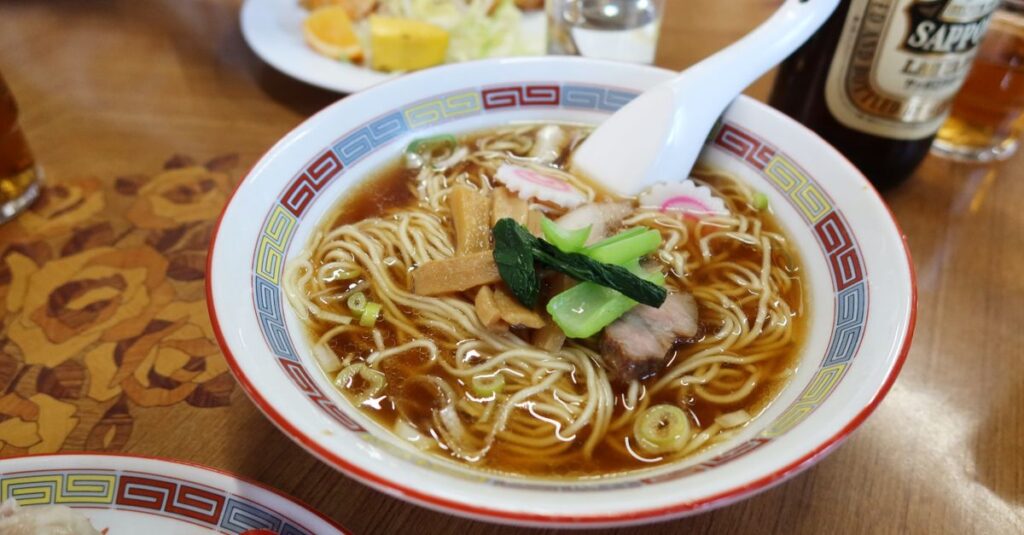 札幌雪まつりの屋台通りで湯気を立てる味噌ラーメンとジンギスカンの香りが漂う風景